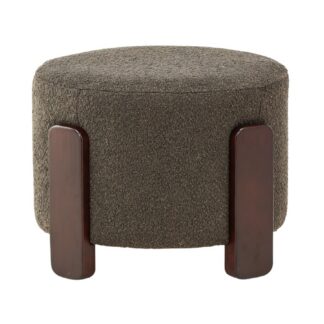 Mörkgrå sittpuff i bouclétyg med brun plywoodstomme placerad i vardagsrum