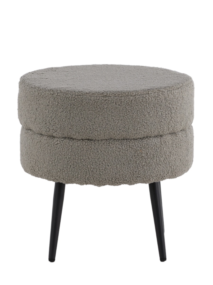 Grå sittpuff i mjukt teddytyg med svarta stålben placerad i modernt vardagsrum