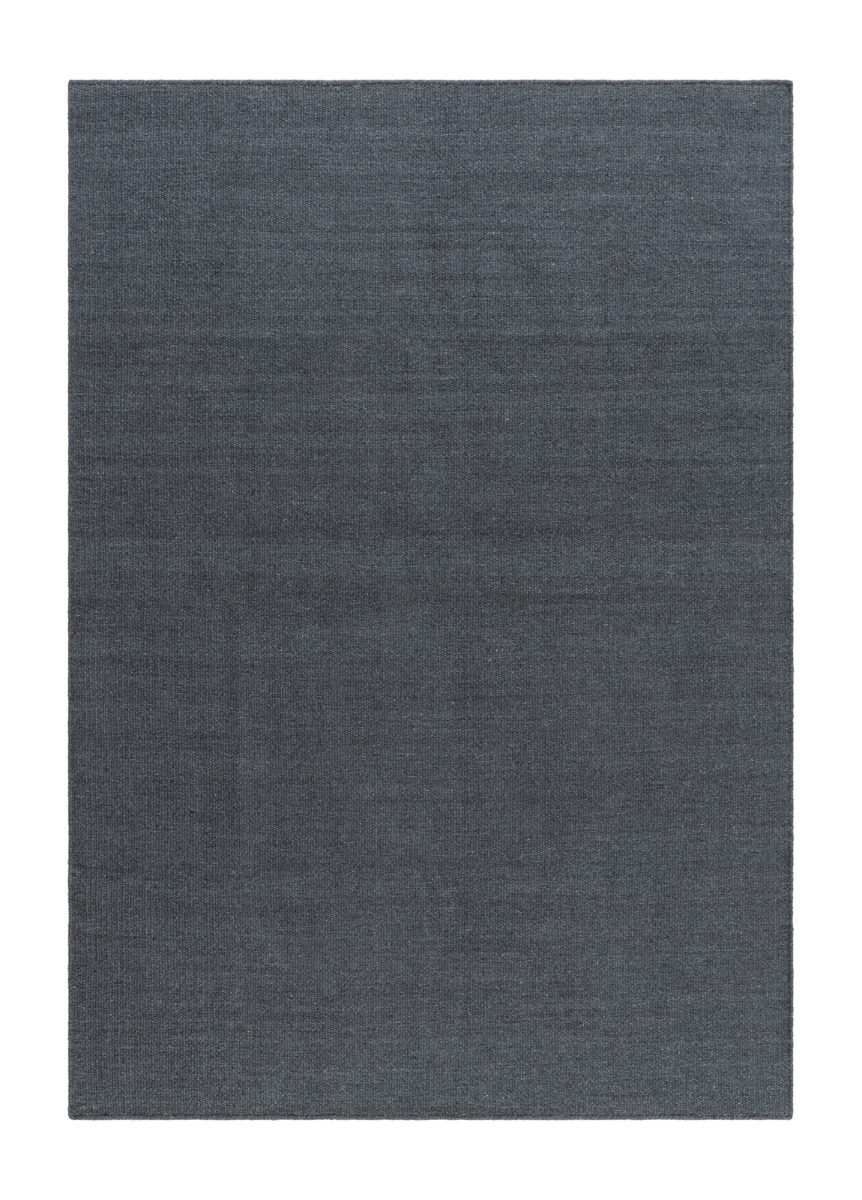 Handvävd grafitfärgad ullmatta med tät väv och naturlig lyster i modernt rum