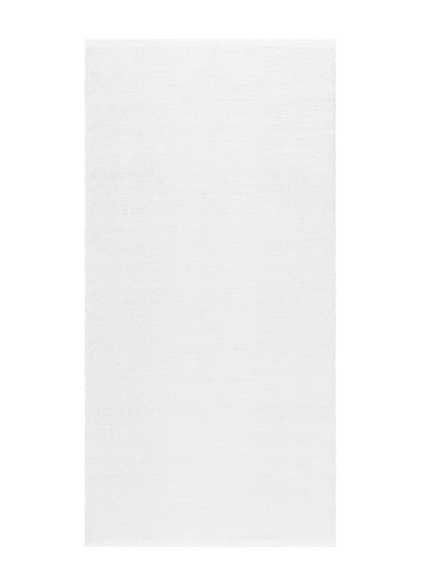 Vit handvävd plastmatta med omvänt mönster i modern inomhusmiljö