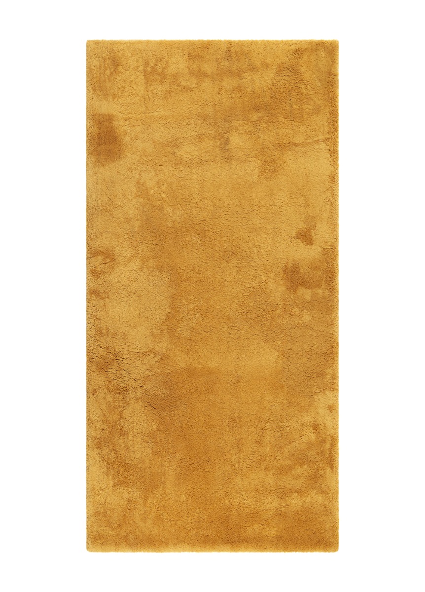 Mjukt ockragult ryamatta med djup lugg och mjuk textur på golv