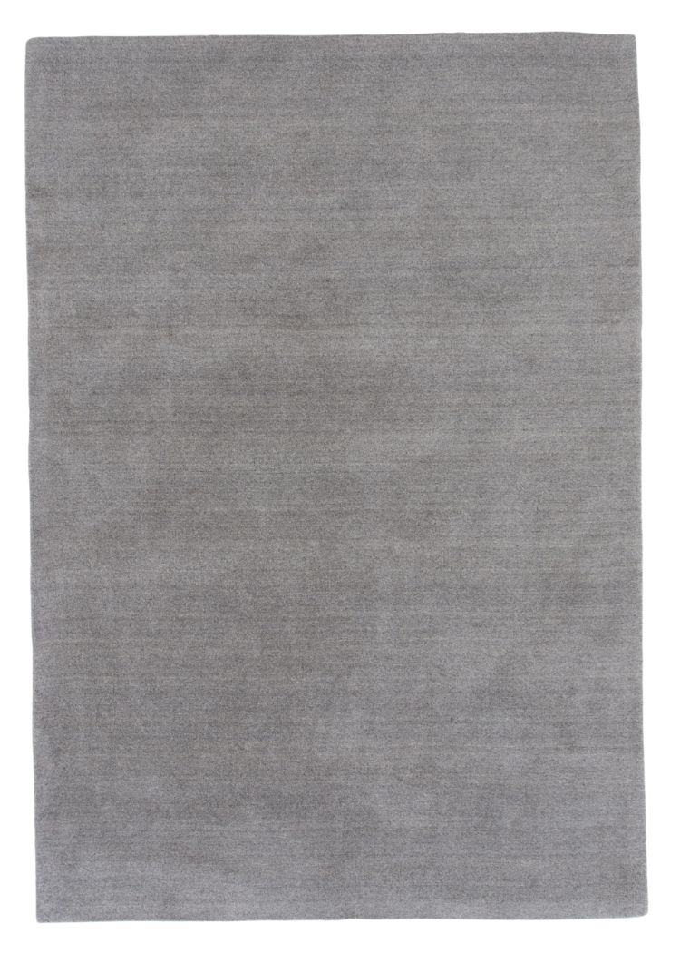 Ljusgrå ullmatta med tjock mjuk lugg på golv i modernt rum