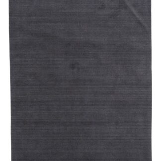 Mörkgrå ullmatta med mjuk lugg och cirka 15 mm tjocklek inomhus