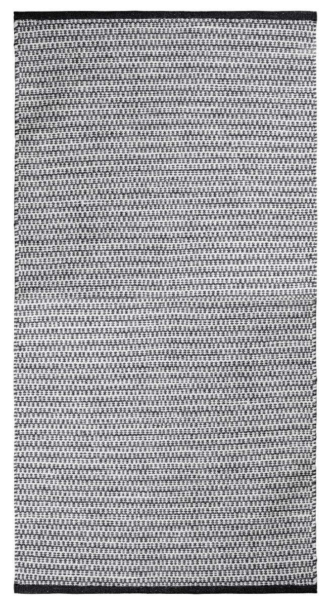 Svart mjuk trasmatta i bomull med ca 10 mm tjocklek liggande på golv i ett inrett rum