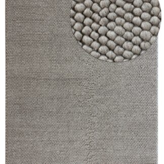 Handgjord grå ullmatta med bubblig tjock struktur i hemmiljö