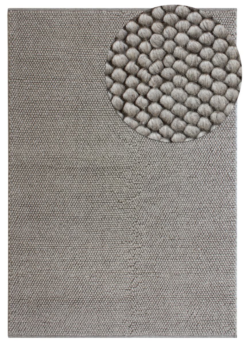 Handgjord grå ullmatta med bubblig tjock struktur i hemmiljö