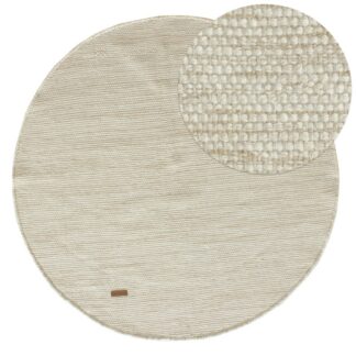 Rund beige ull- och bomullsmatta med mjuk textur i vardagsrumsmiljö