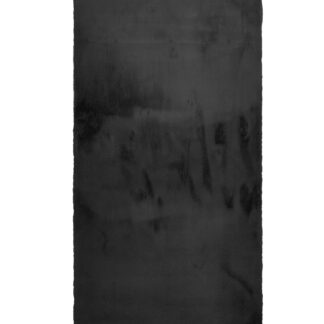 Svart mjuk fällmatta i konstpäls med fluffig struktur placerad i ett modernt hem