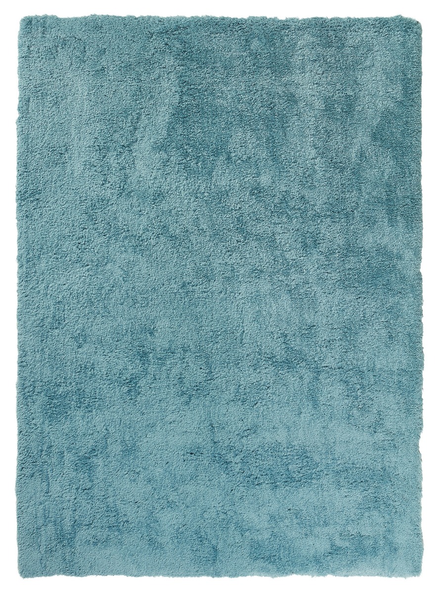 Ljusblå ryamatta med tjock tunn plyschlig lugg i ett modernt vardagsrum