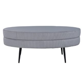 Oval grå sammet sittpuff med svarta utsvängda stålben i modernt vardagsrum