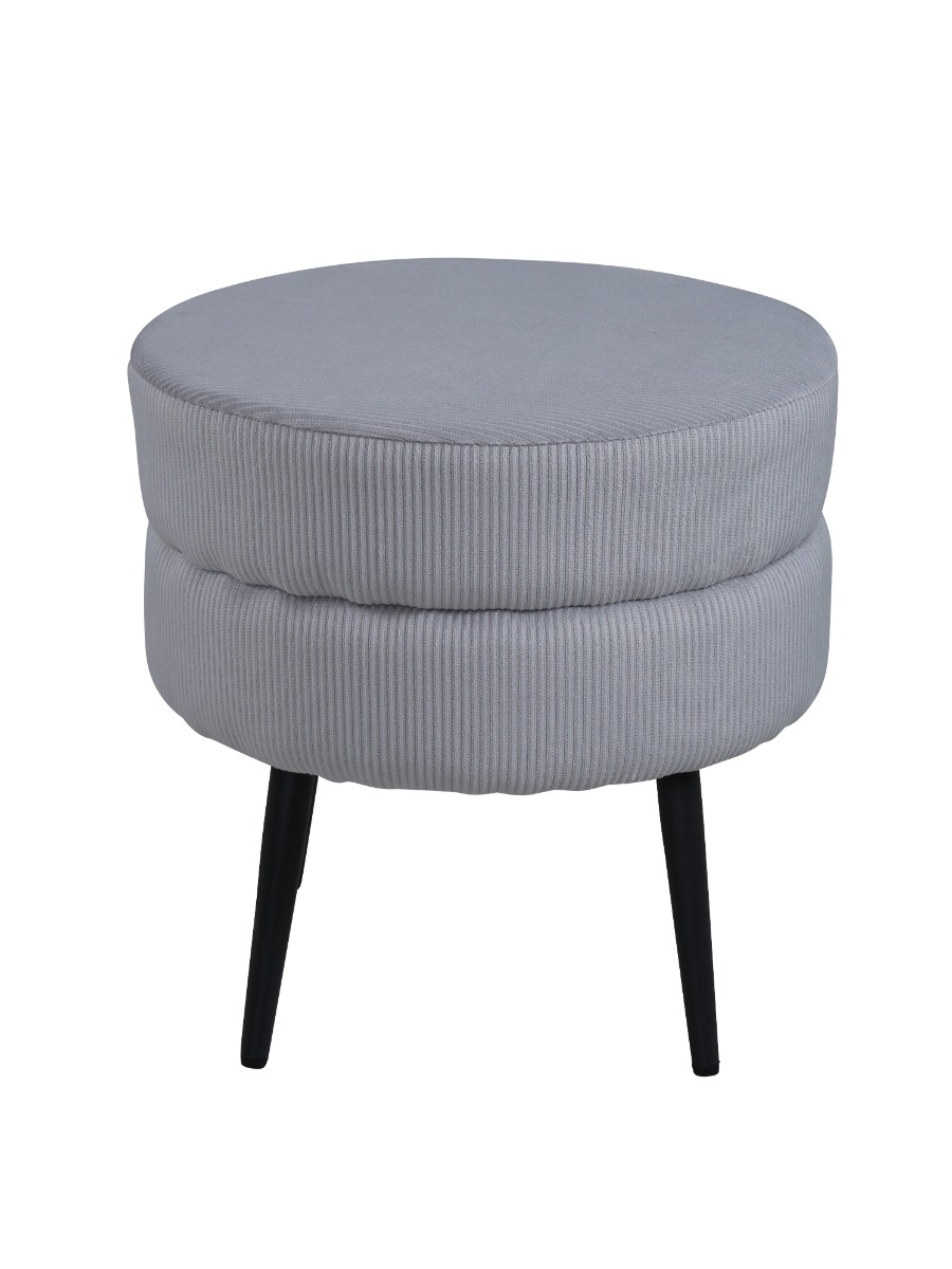 Grå sammetspall med runda svartmålade stålben undangömd vid soffa i modernt vardagsrum
